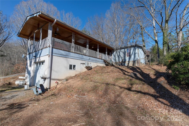 view of property exterior with ceiling fan, a garage, and a balcony