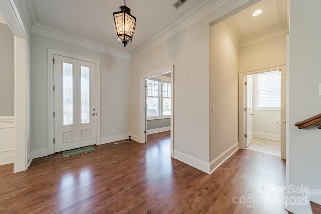 foyer featuring dark wood-type flooring, plenty of natural light, and crown molding