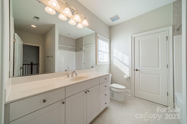 bathroom with toilet, tile patterned flooring, tiled shower, and vanity