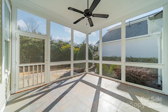 unfurnished sunroom featuring ceiling fan