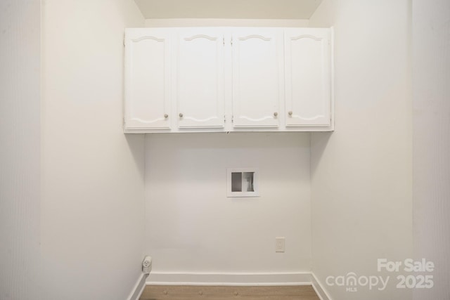 clothes washing area featuring washer hookup and cabinets