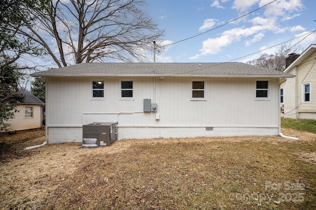 rear view of property featuring a lawn and central AC unit