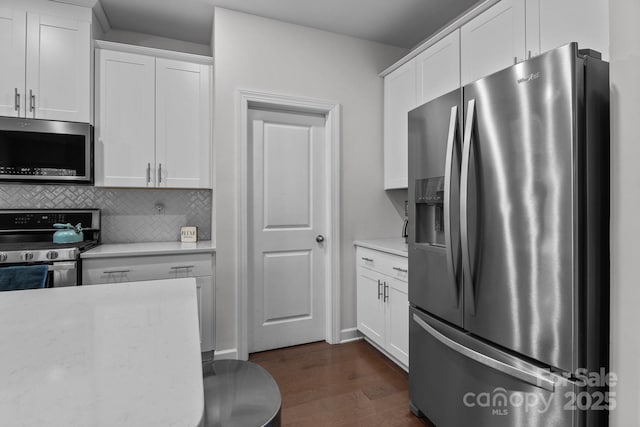 kitchen featuring stainless steel appliances, dark hardwood / wood-style flooring, white cabinets, and backsplash