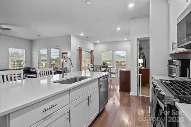 kitchen with stainless steel appliances, sink, a wealth of natural light, and white cabinets