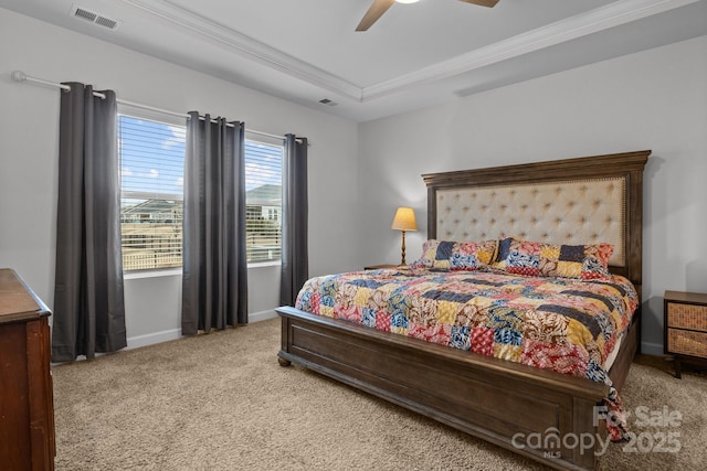 bedroom featuring ceiling fan, ornamental molding, a tray ceiling, and light carpet