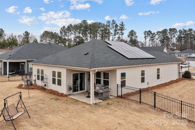 rear view of house featuring a patio area and solar panels