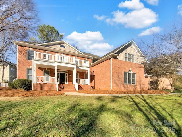 view of front of property featuring a balcony, a front lawn, and a porch