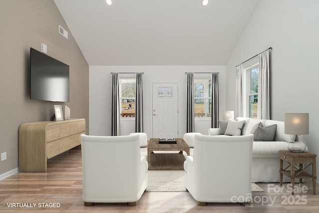 living room with hardwood / wood-style floors and high vaulted ceiling