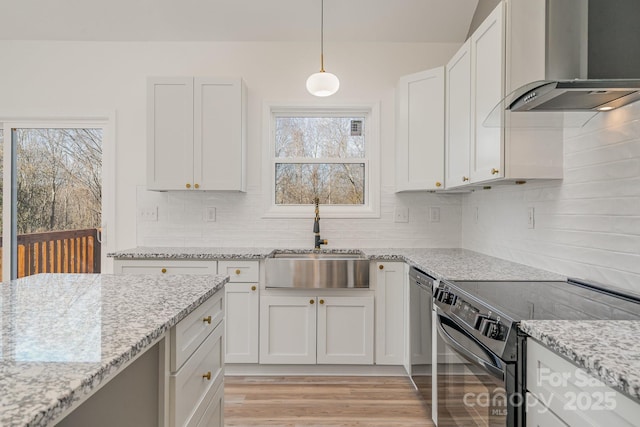 kitchen featuring white cabinetry, sink, hanging light fixtures, wall chimney range hood, and electric stove