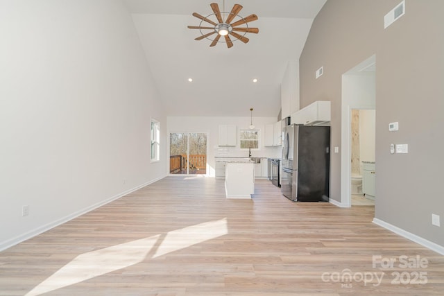 unfurnished living room featuring high vaulted ceiling, light hardwood / wood-style floors, and ceiling fan