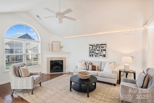 living room featuring ceiling fan, hardwood / wood-style floors, and vaulted ceiling