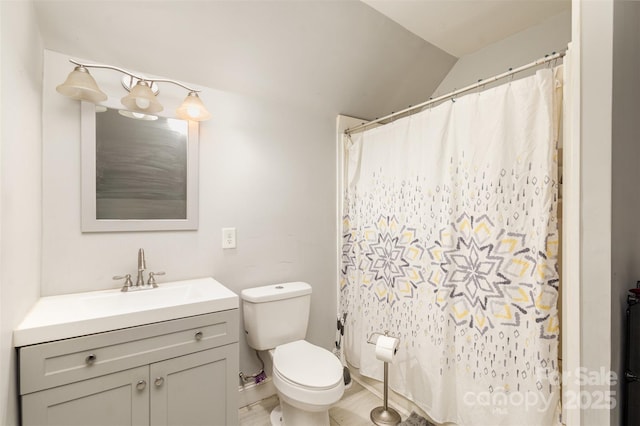 bathroom with toilet, vaulted ceiling, and vanity