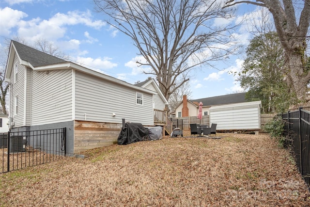 exterior space featuring a wooden deck and a lawn