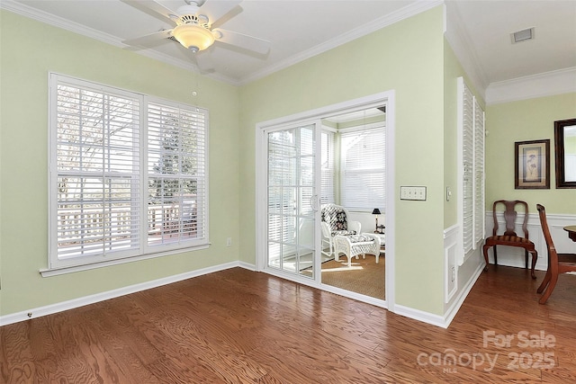 doorway with ceiling fan, plenty of natural light, hardwood / wood-style floors, and ornamental molding