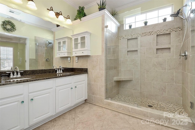 bathroom with an enclosed shower, vanity, crown molding, and a healthy amount of sunlight