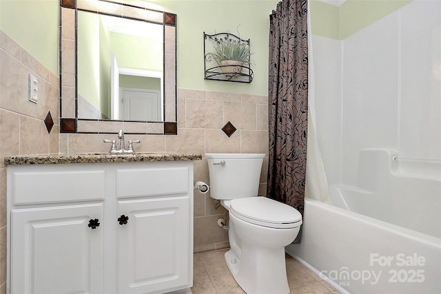 full bathroom with tile patterned flooring, vanity, tile walls, toilet, and shower / bath combo