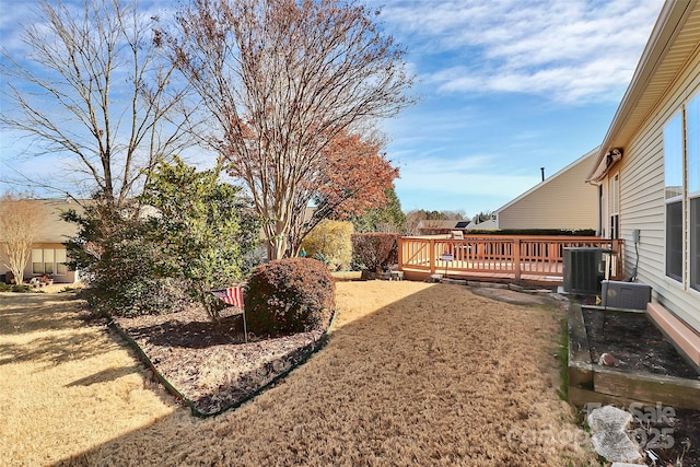 view of yard featuring a wooden deck and central AC