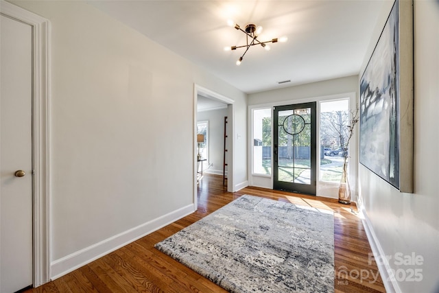 entrance foyer with an inviting chandelier and hardwood / wood-style flooring