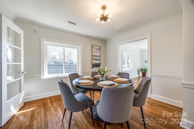 dining area featuring wood-type flooring and ornamental molding