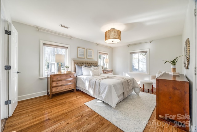 bedroom featuring wood-type flooring and multiple windows