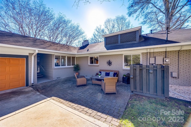 view of patio / terrace with an outdoor living space and a garage