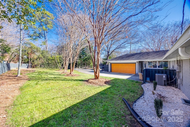 view of yard featuring a garage and central AC unit