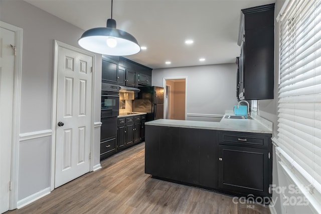 kitchen with sink, hardwood / wood-style floors, and black appliances