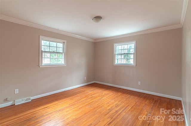 spare room featuring ornamental molding and light hardwood / wood-style floors