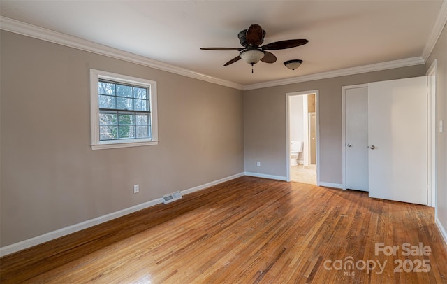 unfurnished bedroom featuring light hardwood / wood-style flooring, ceiling fan, ensuite bathroom, and crown molding