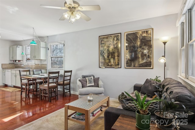 living room featuring hardwood / wood-style flooring, ceiling fan, and sink