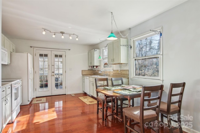 dining room with french doors, hardwood / wood-style flooring, a healthy amount of sunlight, and sink