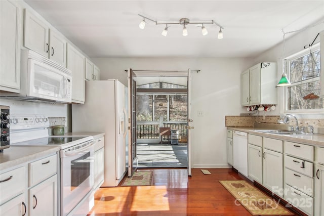 kitchen featuring sink, hardwood / wood-style floors, decorative light fixtures, white appliances, and white cabinets