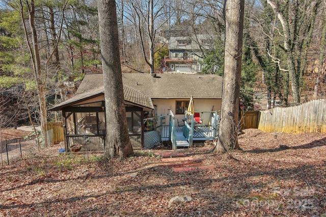 back of house featuring a sunroom and a wooden deck