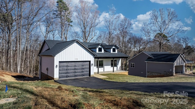 modern farmhouse style home with a garage, a front lawn, and a porch