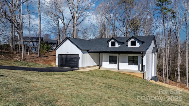 view of front facade with a garage, a front lawn, and covered porch