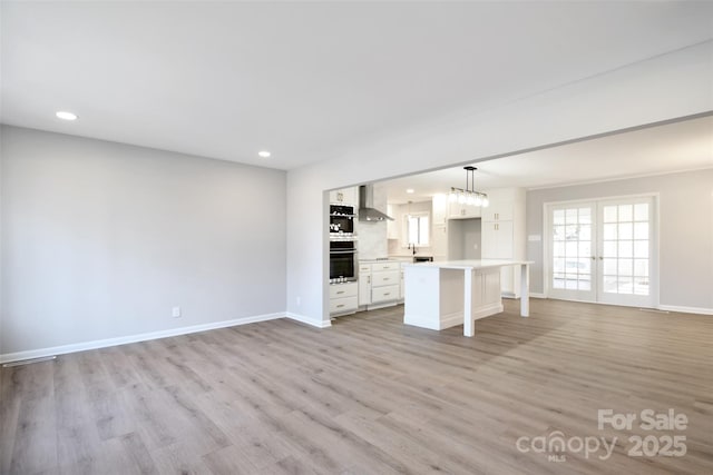 unfurnished living room with french doors and light hardwood / wood-style floors