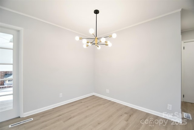 spare room featuring a chandelier, light hardwood / wood-style floors, and crown molding