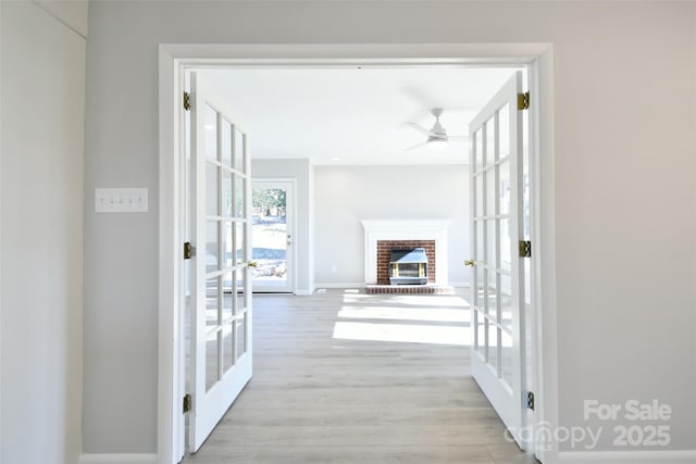 hallway featuring light wood-type flooring and french doors