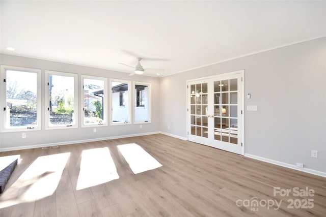 spare room with ceiling fan, french doors, and light hardwood / wood-style floors