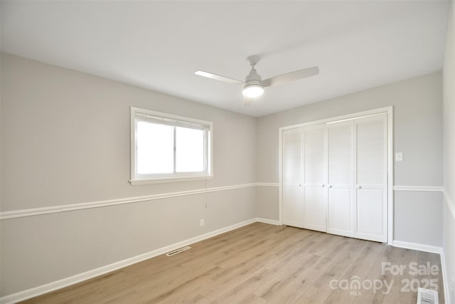 unfurnished bedroom with ceiling fan, light hardwood / wood-style flooring, and a closet