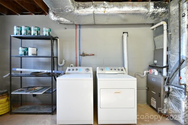 clothes washing area featuring independent washer and dryer and heating unit