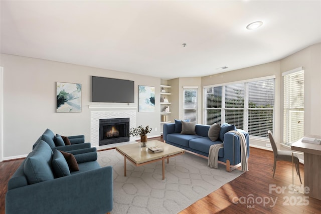 living room featuring a fireplace, plenty of natural light, and hardwood / wood-style flooring