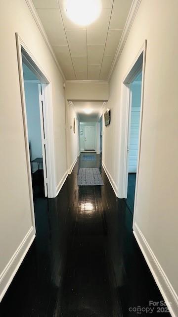 hall with dark hardwood / wood-style floors and crown molding