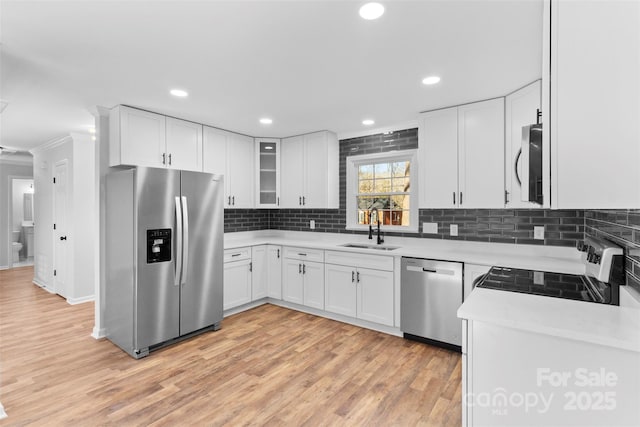 kitchen with decorative backsplash, sink, white cabinetry, and stainless steel appliances