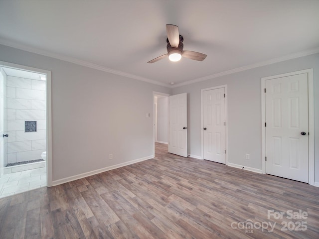 unfurnished bedroom with ceiling fan, ensuite bathroom, hardwood / wood-style flooring, and ornamental molding