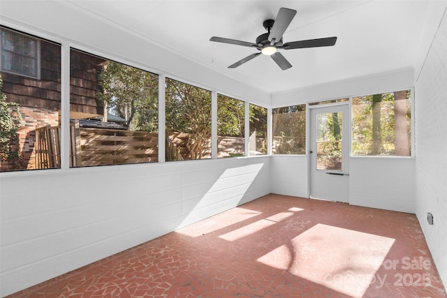 unfurnished sunroom featuring ceiling fan