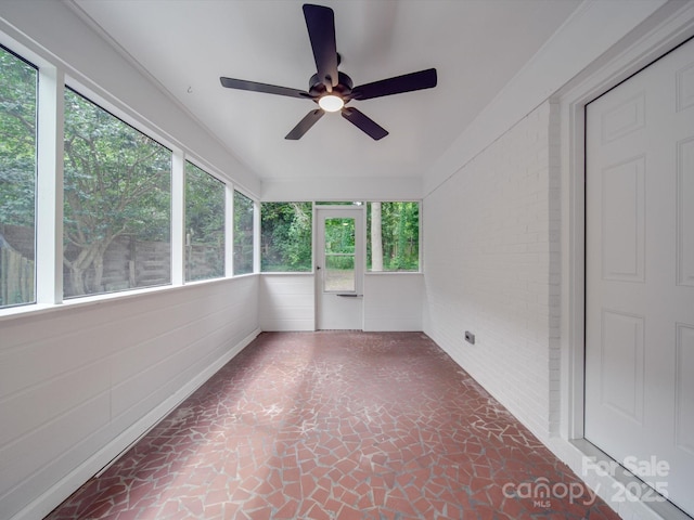 unfurnished sunroom featuring ceiling fan and a wealth of natural light