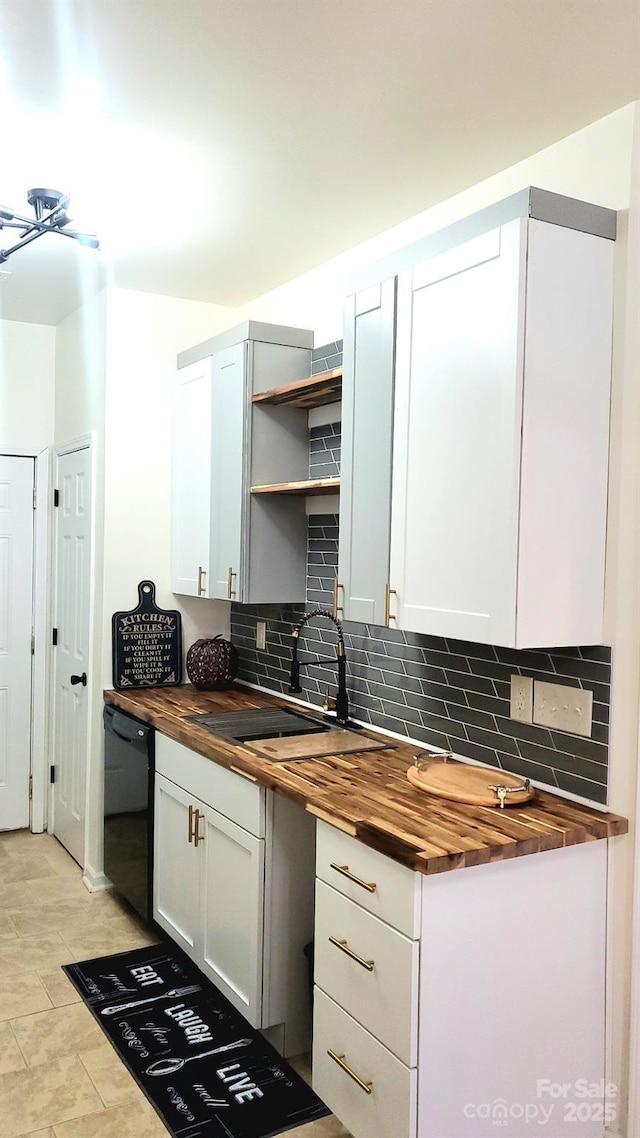 kitchen featuring backsplash, wooden counters, sink, black dishwasher, and white cabinets