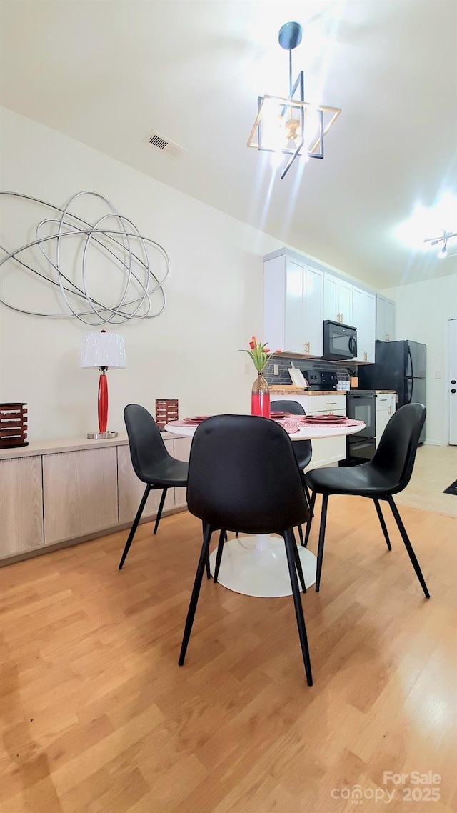 dining area featuring a chandelier and light hardwood / wood-style floors