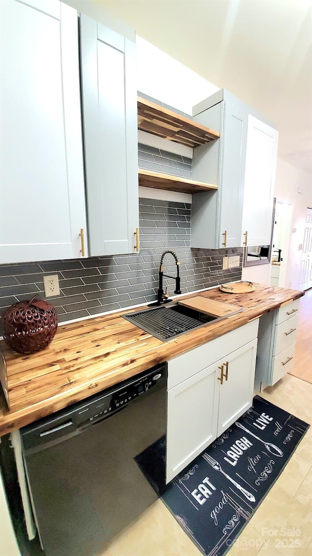 kitchen featuring black dishwasher, white cabinetry, and butcher block countertops